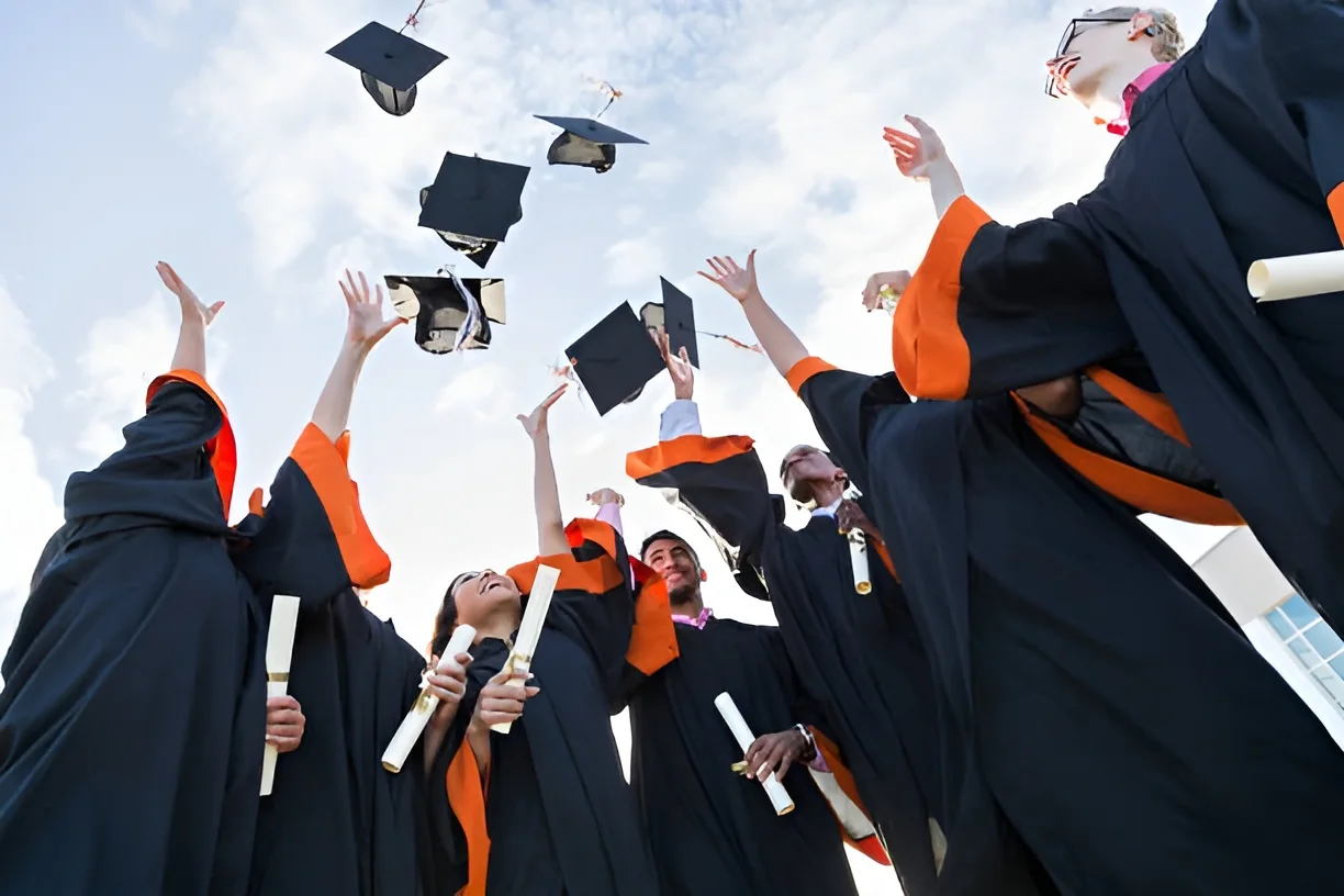Graduates throwing their caps in the air at commencement