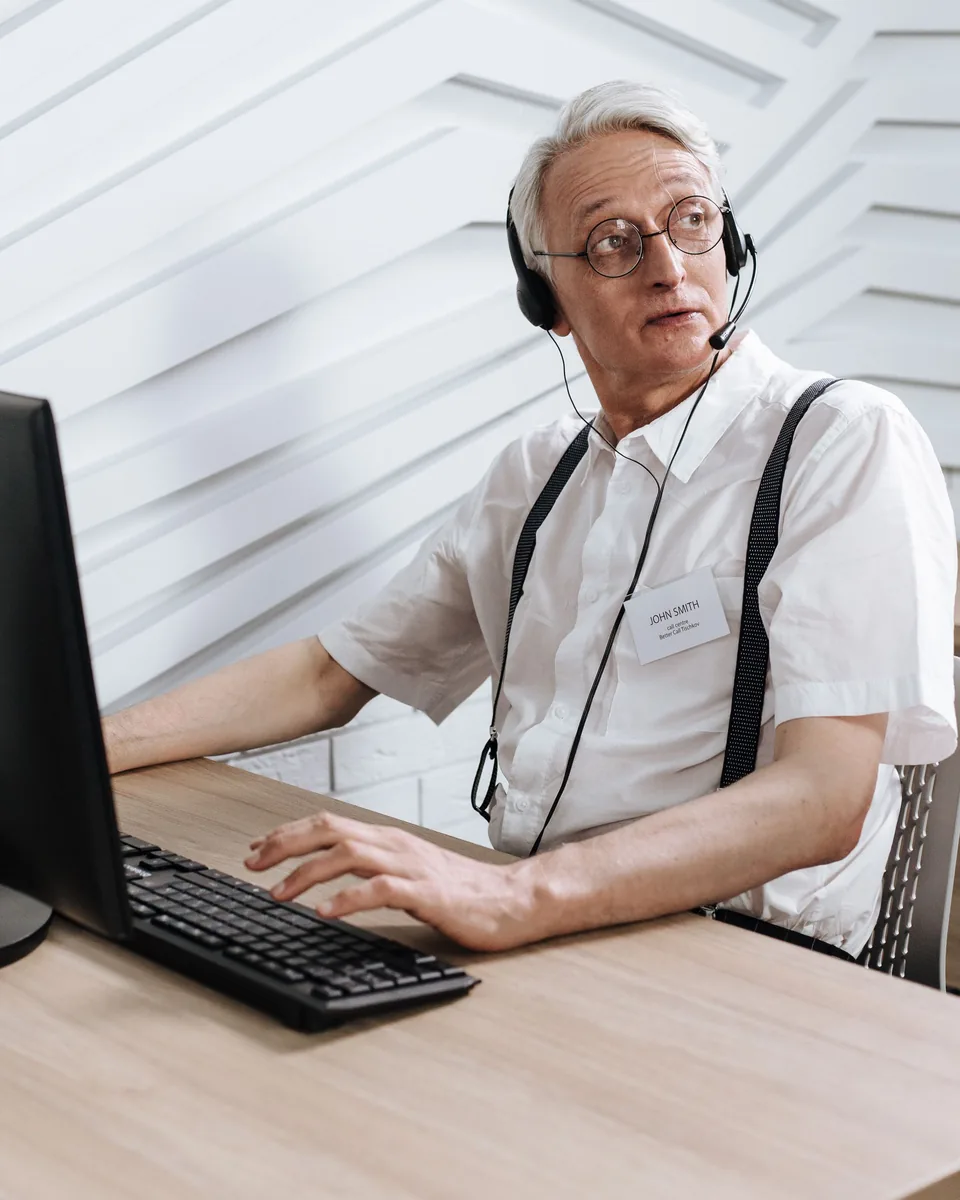 Employee wearing a headset microphone working at a desktop computer